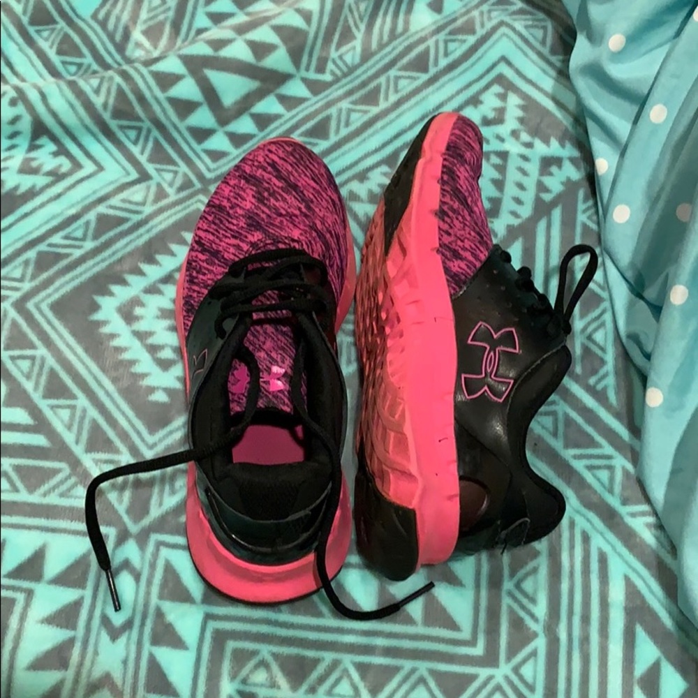pink and black Underarmour tennis shoes